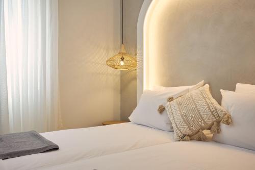 a bedroom with a bed with white pillows and a lamp at Ducato di Zante Luxury Beach Villa, by ZanteWize in Kipseli