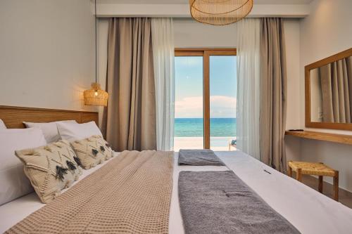 a bedroom with a bed with a view of the ocean at Ducato di Zante Luxury Beach Villa, by ZanteWize in Kipseli
