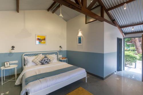 a bedroom with blue and white walls and a bed at Villa Aangan by StayVista - A heritage charm with Swimming pool, Gazebo, Projector room & Indoor games in Lonavala