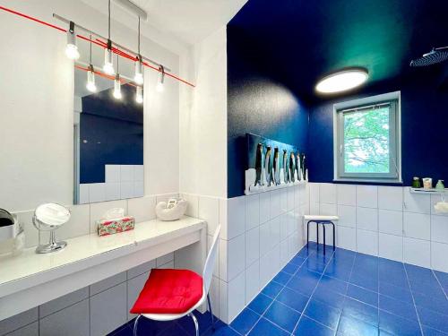 a blue and white bathroom with a red chair at Ferienbungalow Iwele Marktbreit in Marktbreit