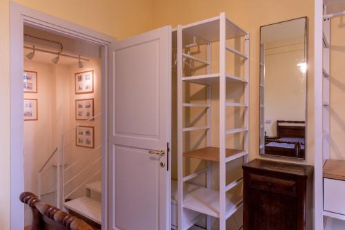 a closet with a white book shelf next to a door at Casa nella campagna Parmigiana. in Stradella
