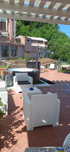 a patio with white chairs and tables and a building at La Terrazza Quisisana Sorrento Coast in Castellammare di Stabia