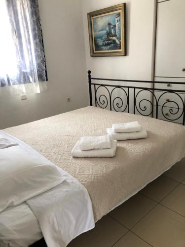 Una cama con dos toallas encima. en Villa 33 en Monolithos