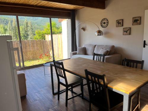 a living room with a table and chairs and a couch at Barcelonnette location avec jardin in Barcelonnette