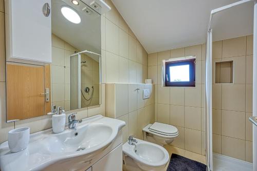a bathroom with a sink and a toilet at Holiday House Iris with Private Pool in Poreč