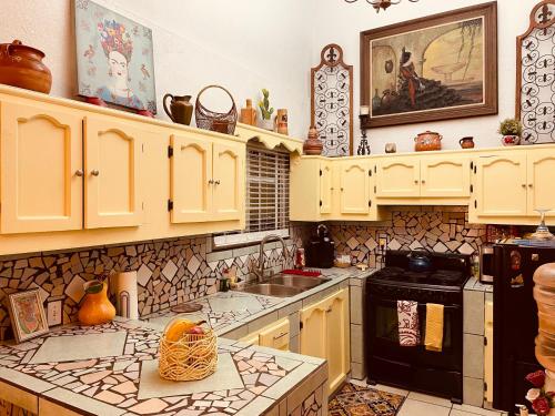 una cucina con armadi gialli e piano cottura. di Cozy Apartment Villas a Rosarito