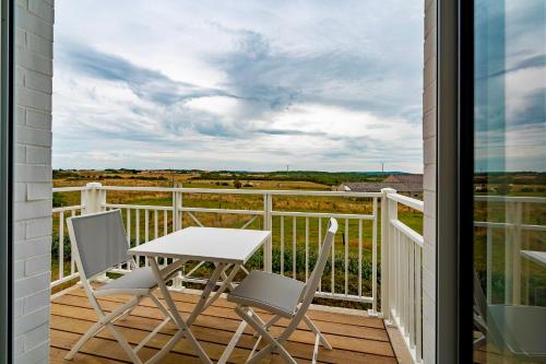- une terrasse couverte avec une table et des chaises sur un balcon dans l'établissement Evancy Equihen-Plage, à Équihen-Plage