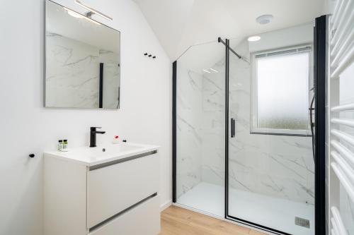 a white bathroom with a shower and a white sink at Evancy Equihen-Plage in Équihen-Plage