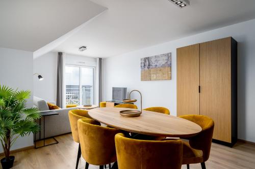 a dining room with a wooden table and yellow chairs at Evancy Equihen-Plage in Équihen-Plage
