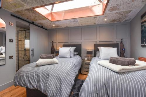 a bedroom with two beds and a skylight at The Hideaway 
