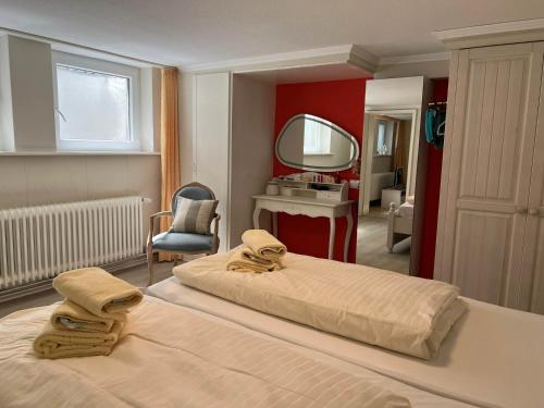 a bedroom with a large bed and a mirror at Up de Kek im Friesenhaus Sieben Linden in Archsum