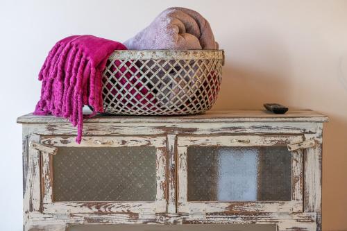 a basket sitting on top of a wooden cabinet with a table at Suite Kolibri in Galilee in Semadar