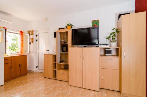 ein Wohnzimmer mit einem TV auf einem Holzschrank in der Unterkunft Apartment Mala Ana in Dubrovnik