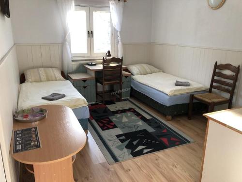 Habitación pequeña con 2 camas y mesa. en Zajazd Private, en Suwałki