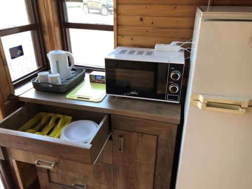 a kitchen with a microwave on a counter next to a refrigerator at Zajazd Private in Suwałki