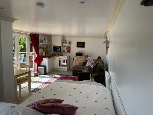 a living room with a bed and a kitchen at Unique Orchard Lodge for couples with hot tub in Strathaven