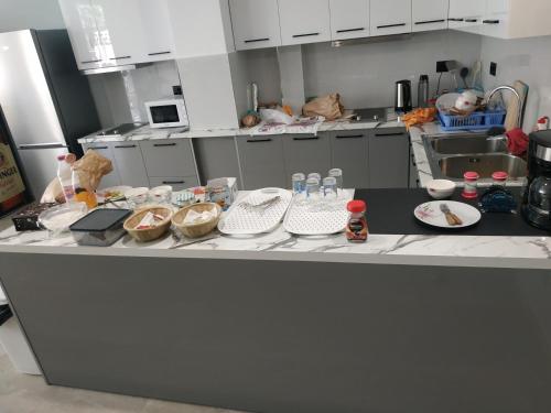 un bancone della cucina con piatti di cibo sopra di Central Boutique Hostel a Sarandë