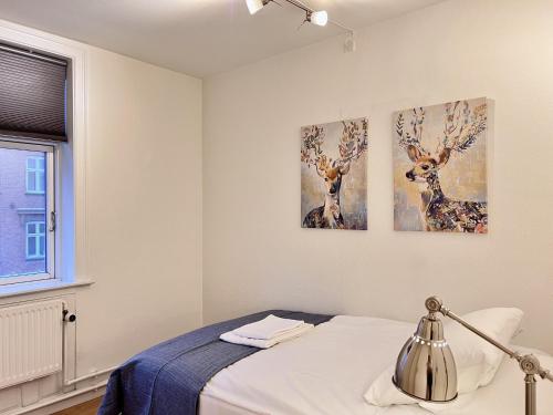 a bedroom with three paintings of deer on the wall at Two Bedroom Apartment In Copenhagen, Amagerbrogade 93, in Copenhagen