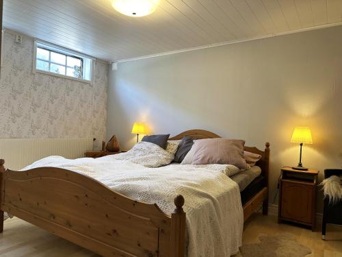 a bedroom with a bed and two lamps and a window at Unique villa with spa and sauna in Tanumshede in Tanumshede