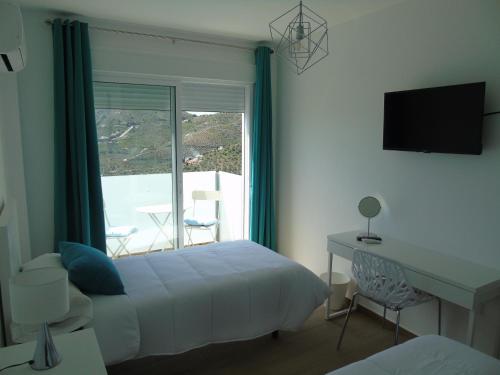 Schlafzimmer mit einem Bett und einem Fenster mit Aussicht in der Unterkunft Villa Esperanza - Canillas de Albaida in Canillas de Albaida