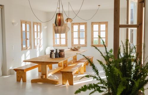 une salle à manger avec une table et des bancs en bois dans l'établissement Scorpios Beach, à Monolithos