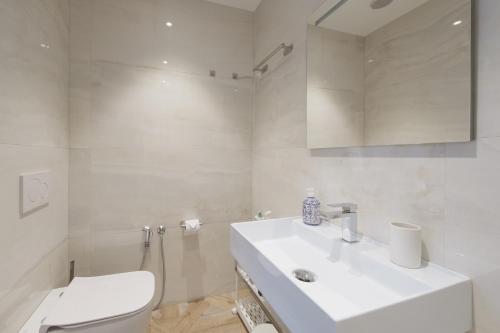 a white bathroom with a sink and a toilet at Supernova in Savona