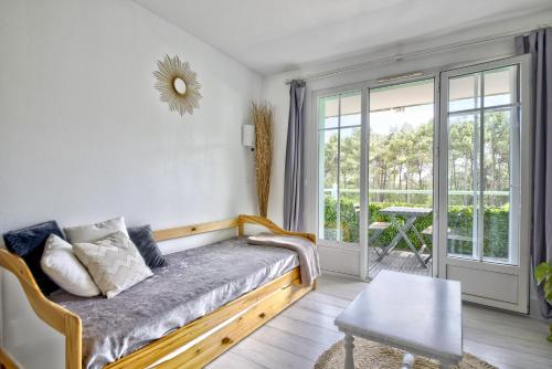 une chambre avec un lit et un balcon avec une table dans l'établissement Appartement rénové et cosy dans résidence vacances, à Lacanau-Océan