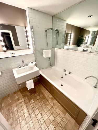 a white bathroom with a tub and a sink at Gleneagles Lettings in Auchterarder