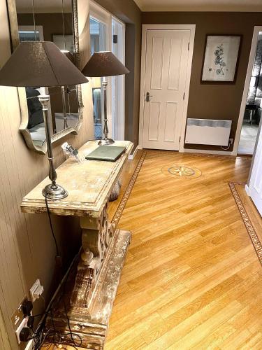 a living room with a wooden floor and a table at Gleneagles Lettings in Auchterarder
