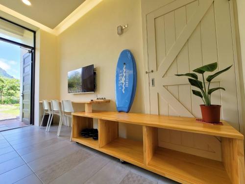 un salon avec une planche de surf sur le mur dans l'établissement 墾丁夏林灣民宿 包棟Villa-停車場-烤肉-近墾丁大街-大灣沙灘, à Kenting