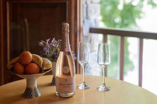 Casa Can Rufo de Rupit في روبيت: زجاجة من الشمبانيا وكأسين من النبيذ على الطاولة