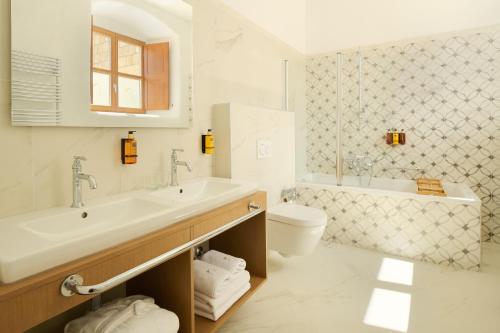 a white bathroom with a sink and a toilet at Palace Natali in Dubrovnik