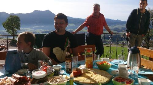 a group of people sitting around a table with food at Gesundheitshof Lohninger in Mondsee