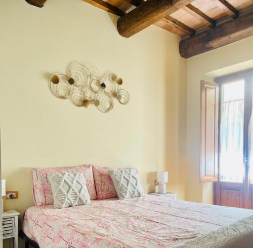a bedroom with a bed with a pink blanket and a window at relais L’Imperatore in Prato