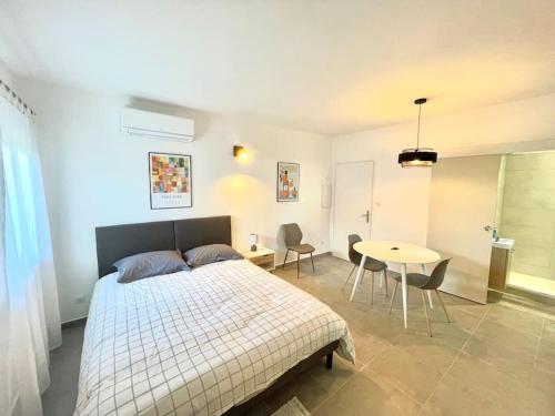 a bedroom with a bed and a table with chairs at Appartement Hypercentre Parking Gratuit in Ajaccio