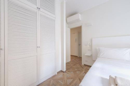 a white bedroom with a bed and a closet at Supernova in Savona