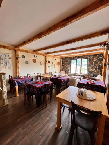 ein Restaurant mit Tischen und Stühlen in einem Zimmer in der Unterkunft Ioska's House in Mestia