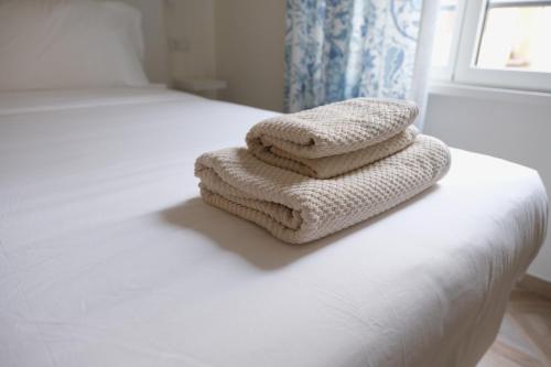 two towels sitting on the edge of a bed at Supernova in Savona