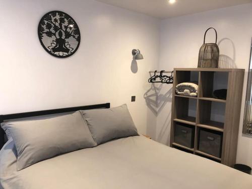 a bedroom with a bed and a clock on the wall at Ash Cottage in Skegness