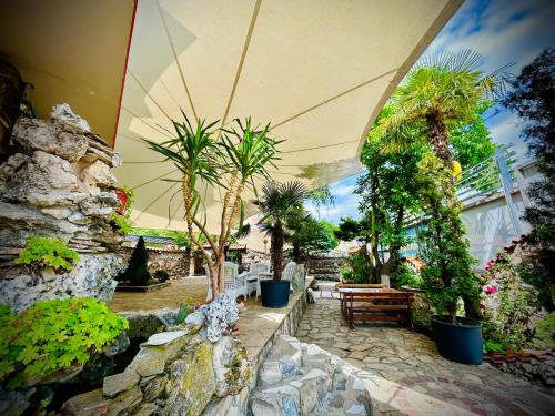 a garden with a bunch of plants and benches at Meatsa Hotel in Kŭrdzhali