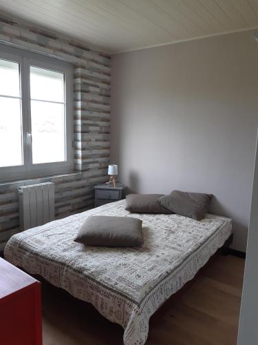 a bedroom with a bed with two pillows on it at Maison bord de mer Penmarch in Penmarcʼh