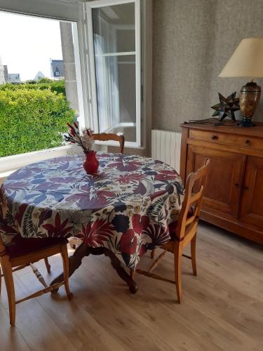 d'une table, de chaises et d'une fenêtre. dans l'établissement Maison bord de mer Penmarch, à Penmarcʼh