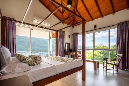 a bedroom with a bed and a large window at Villa Victoria Edge in Digana