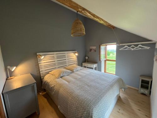 a bedroom with a large bed and a window at La maison des commis in Morestel