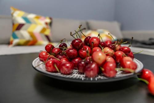 a pile of cherries on a plate on a table at Apartman Pletisanak in Gornji Milanovac