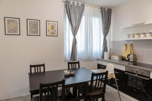 een keuken en eetkamer met een tafel en stoelen bij Apartman Pletisanak in Gornji Milanovac