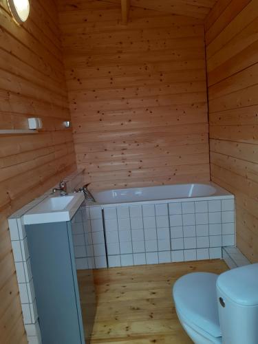 a bathroom with a tub and a toilet at Domki letniskowe nad morzem in Pogorzelica