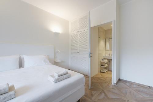 a white bedroom with a white bed and a bathroom at Supernova in Savona