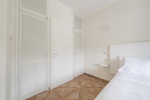 a bedroom with white walls and a bed and wooden floors at Supernova in Savona
