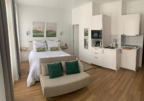 een grote witte slaapkamer met een bed en een bank bij GuimaraesLiving - Hostel & Adventure in Guimarães